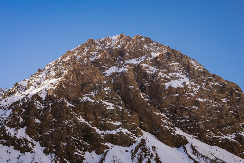 a massive jagged mountain seen from its base, monumental mountain 4k