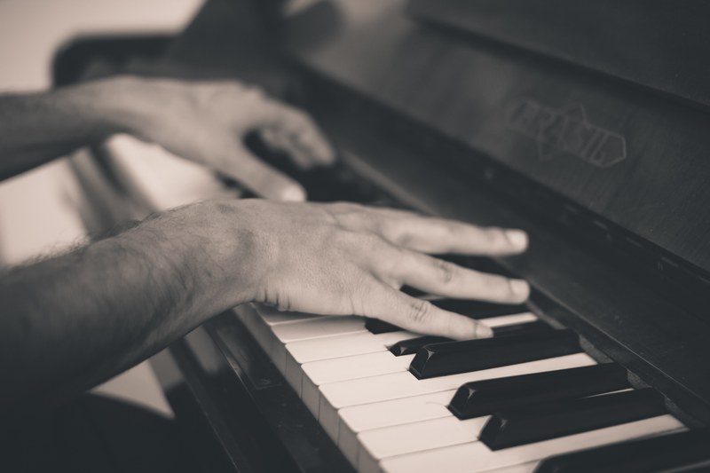 a black and white shot of a mans hands playing the piano, pianists hands in black and white 4k