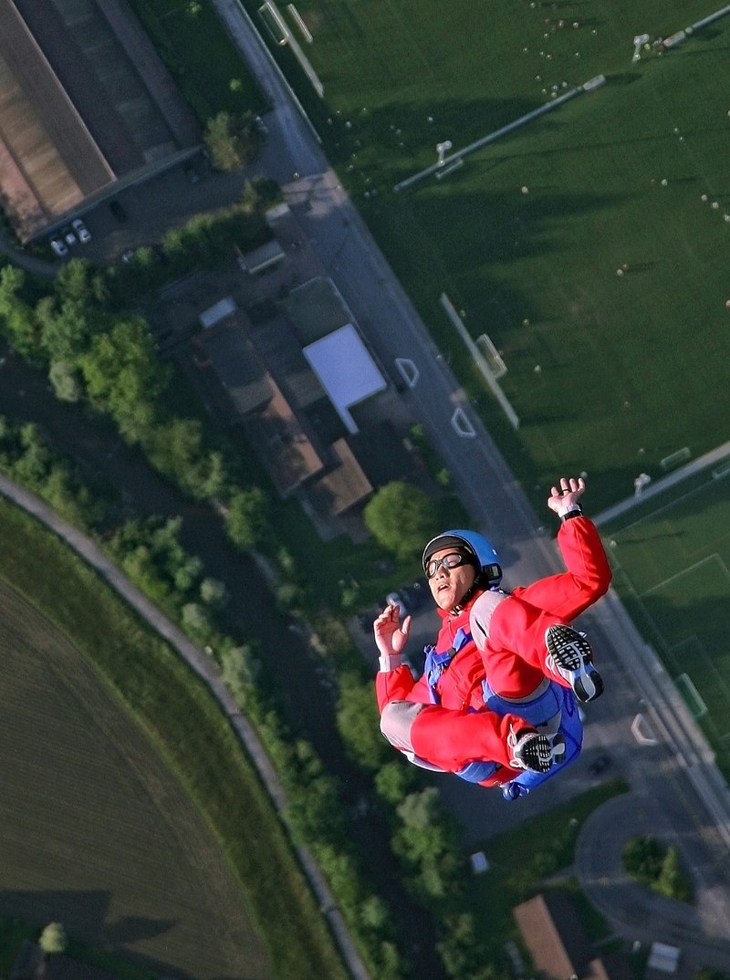 an aerial photo of a person falling toward the ground as they skydive in zug, jumping 4k