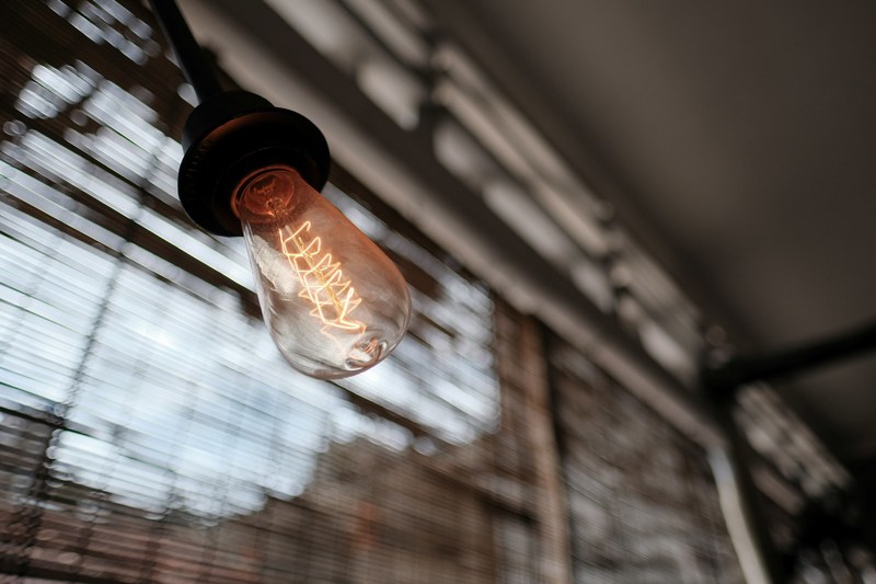 burning filament in a light bulb near a window, light over linear bokeh_ 4k