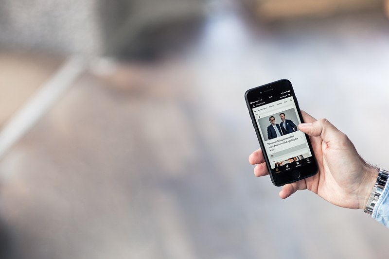 a person browsing articles in an app on a black iphone, whats happening 4k