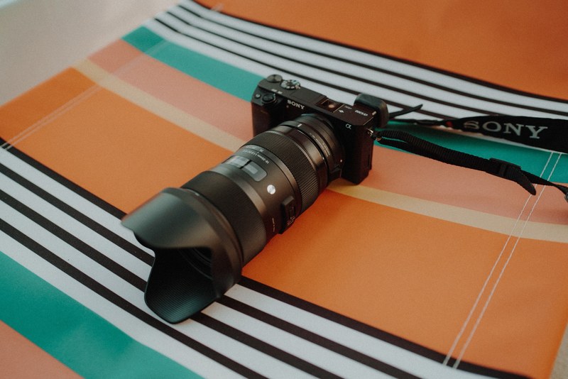 sony camera with a lens on a striped beach blanket, beach photography 4k