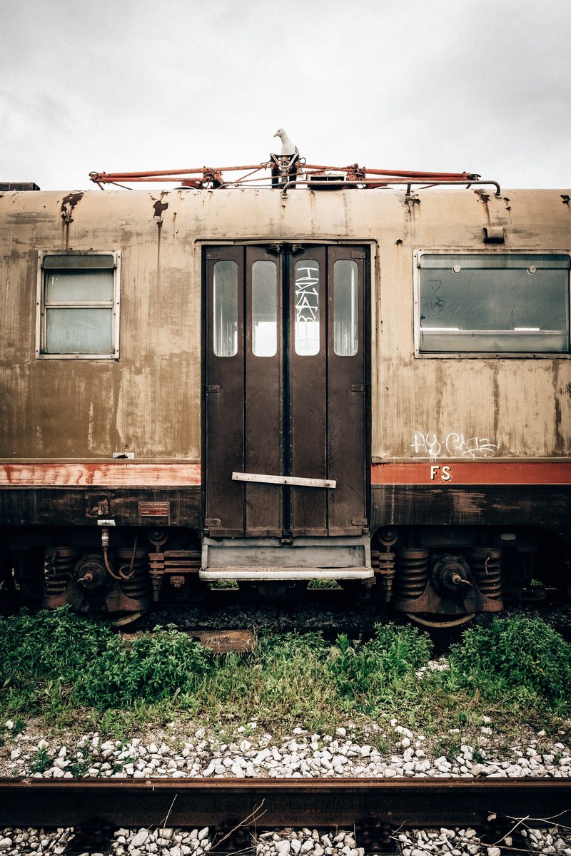 abandoned train car on old tracks surrounded by weeds and rocks, old train 4k