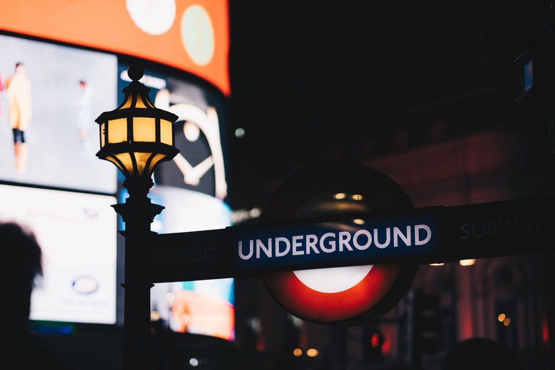 underground sign on lamp post at night in the city, picadilly 4k