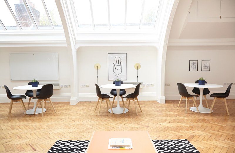 an open office space with round tables and posters on the walls, cozy open office space 4k