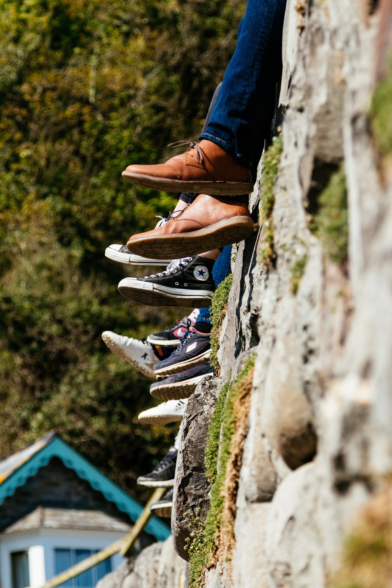 people sat on a wall shoes and converse 4k
