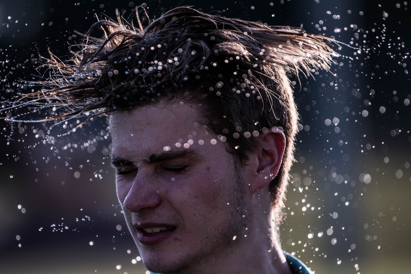 man shaking his wet hair out and spraying water, wet hair 4k