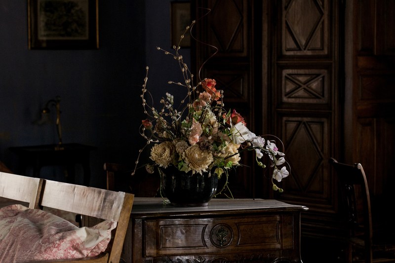 a black vase with various kinds of flowers and catkins on an elegant wooden cabinet, elegant flower vase 4k