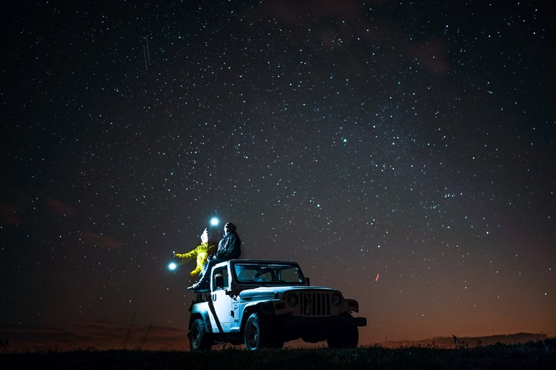 two people sitting on top of their jeep in virginia underneath a starry night sky, ranching under the stars 4k