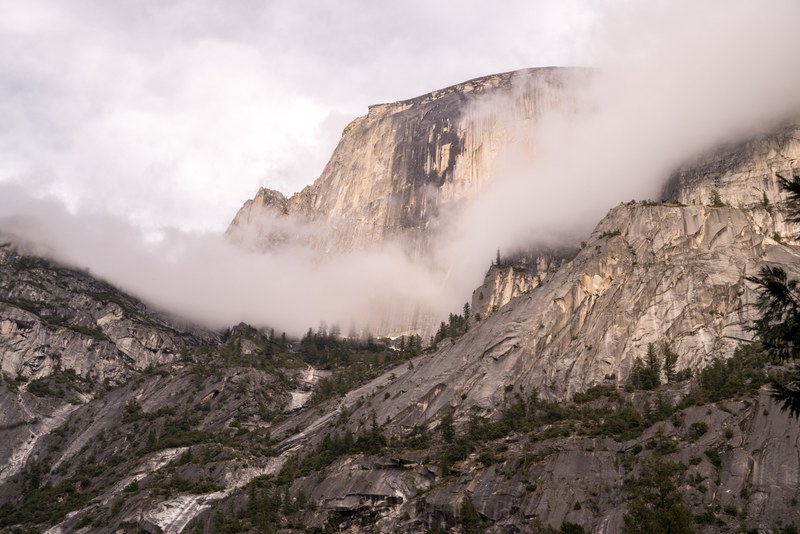 rocky facade in yosemite national park covered in fog, half dome sunset 4k