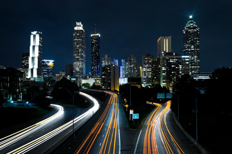 a night time shot of traffic light trails on the jackson street bridge with the cityscape in the background, jackson street bridge 4k