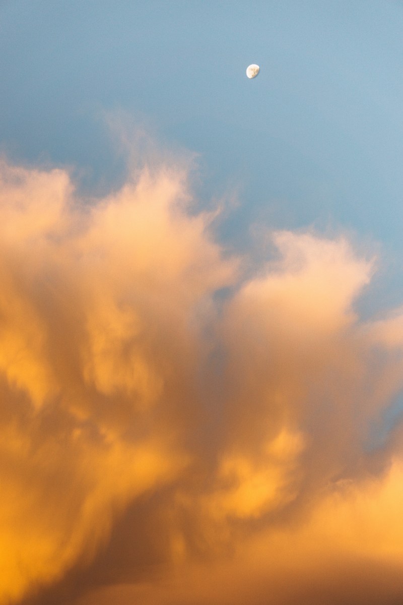 the moon rising during a sunset where the sky is bright orange and blue in portland, sunset in the city 4k