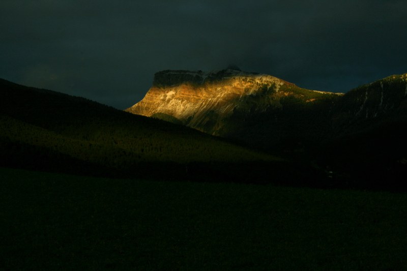 the last rays of sunshine fall on a tall mountain as the evening sets in, the alps with a sun scarf_ 4k