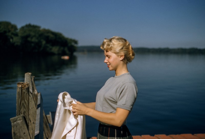 woman with a vintage updo hairstyle holding a jacket by the lake, vintage hair 4k