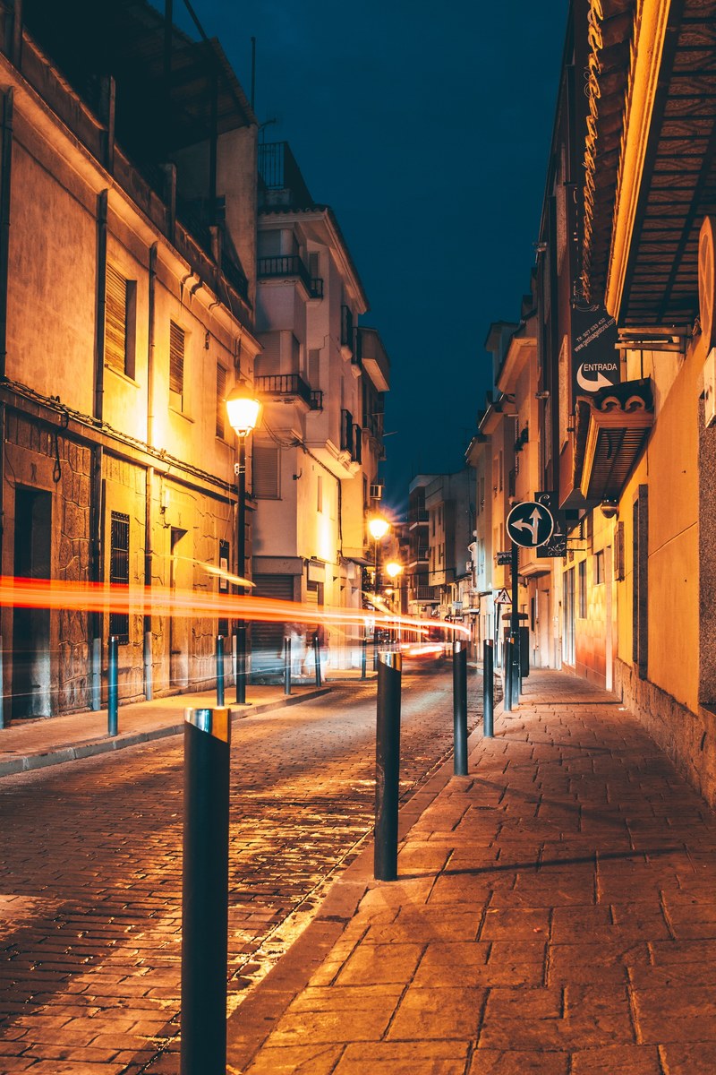 an early night shot of a street and the sidewalk in a historic part of town, historic architecture and light trails 4k