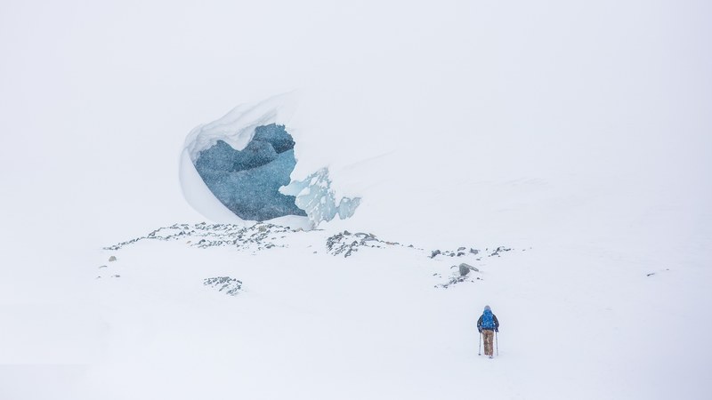 a landscape of a hiker walking in the snow to a ice cave, hiker heading to ice cave 4k