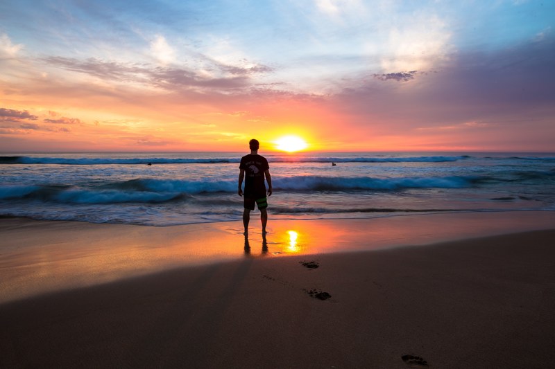 man standing on the sands of gunnamatta ocean beach watching the sunset and the crashing waves, gunnamatta sunset 4k