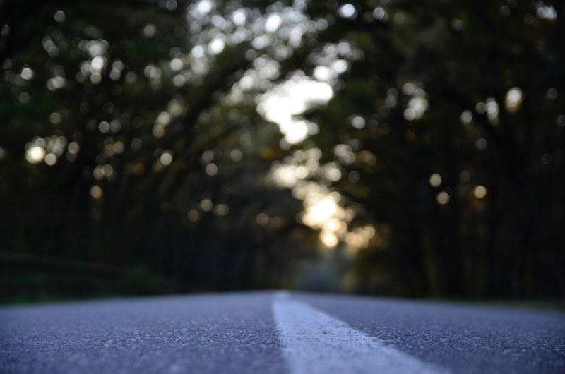 a low shot of the surface of an asphalt road with bokeh effect in the background, asphalt road surface 4k