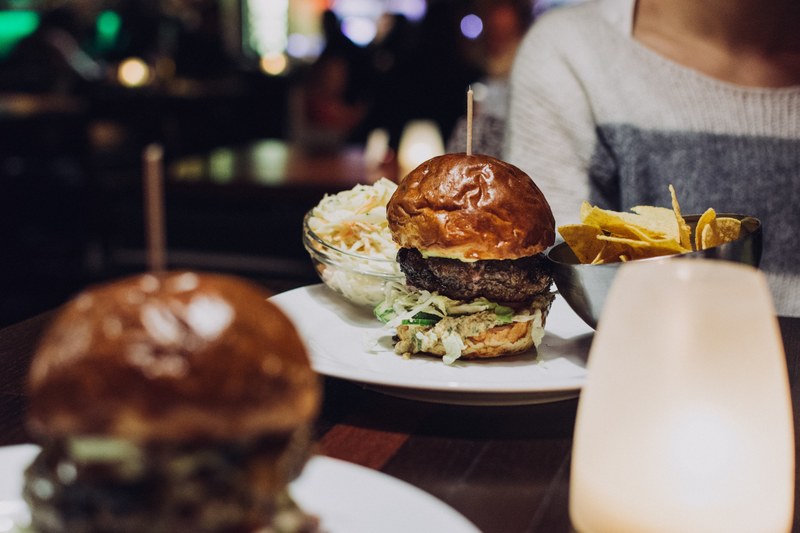 full plates of burgers and chips on the table at a bar and grill restaurant, beef burger in a restaurant 4k