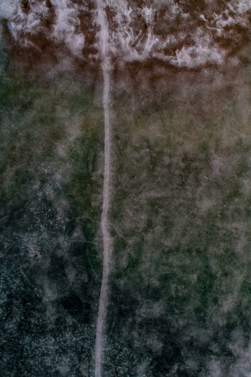 a drone shot of a road through a frozen wasteland, frozen road 4k