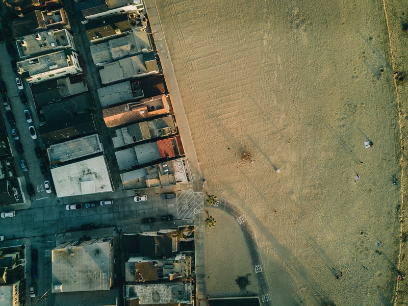 drone aerial view of dense housing by the sand beach at newport beach, streetside beach 4k