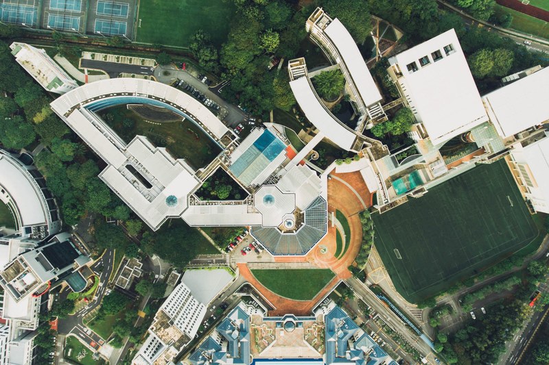 drone view of buildings and sports fields surrounded by green landscaping in singapore, buildings fields singapore 4k