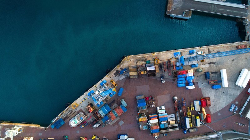 an overhead shot of saint peter port with shipping containers next to the calm sea, the docks in st_ peter port guernsey 4k