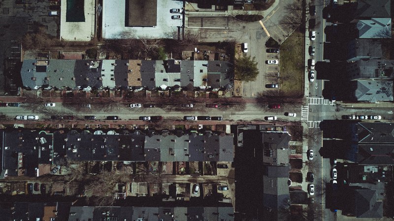 drone view of suburbs house roofs and cars on streets, enemy of the state 4k