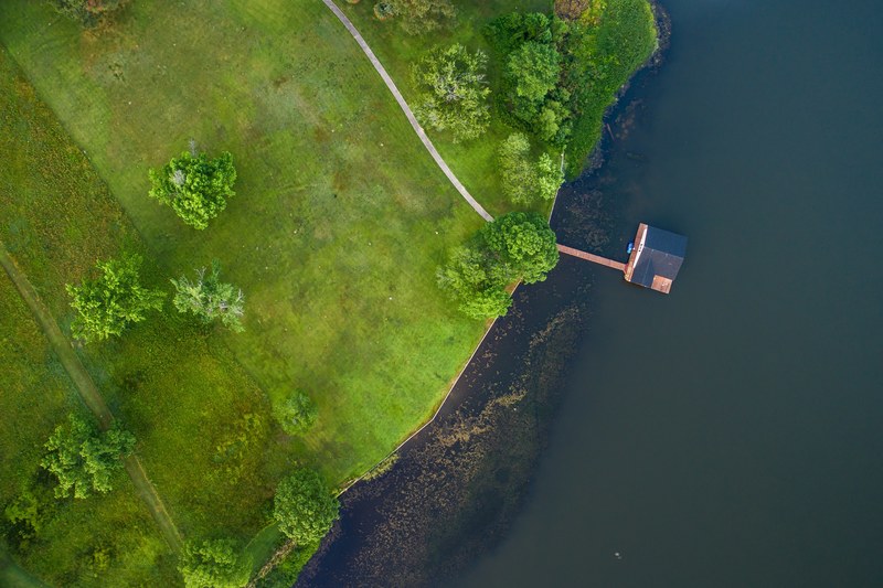 overhead view of a cabin on the lake near a green landscape, cabin on the lake 4k
