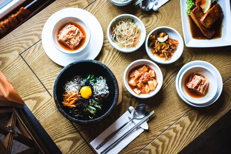overhead shot of table with bowls of pho kimchi and korean food, korean food bibimbap with kimchi 4k