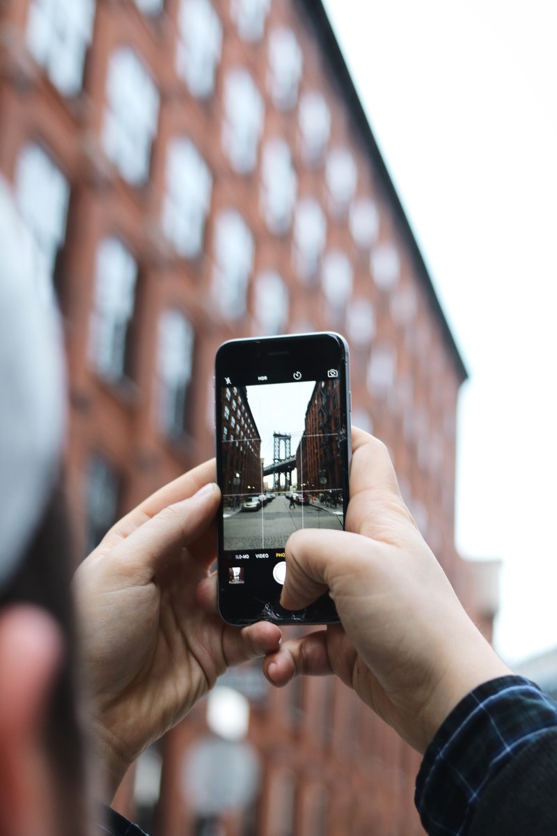 a person taking a picture of urban buildings with their phone, _phone camera buildings 4k