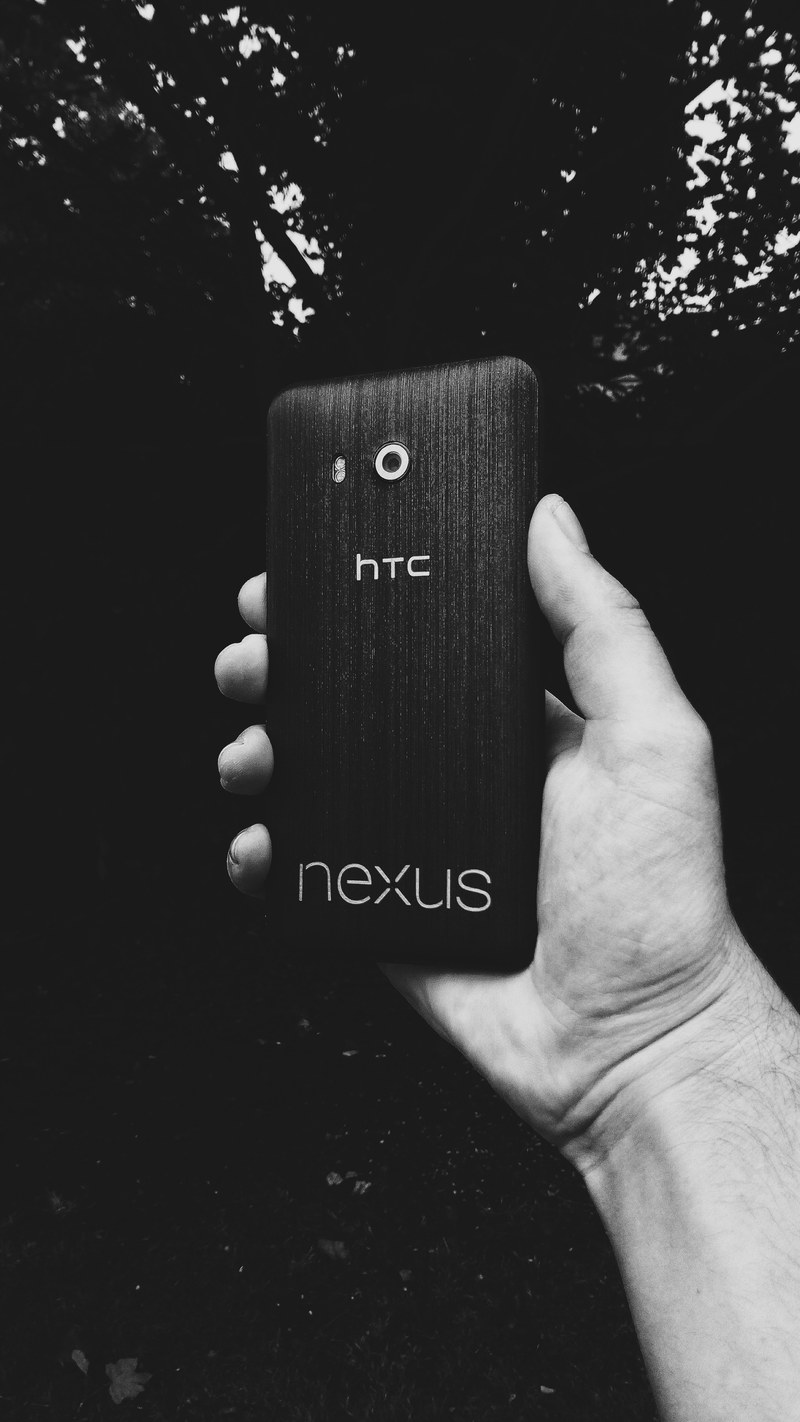 a blackened photo of a person holding a black smartphone, _black phone in hand 4k