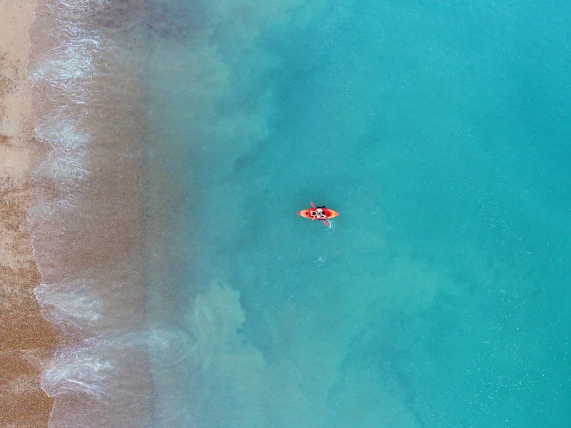 a drone view of a person kayaking in the sea in brighton, kayak drone view 4k