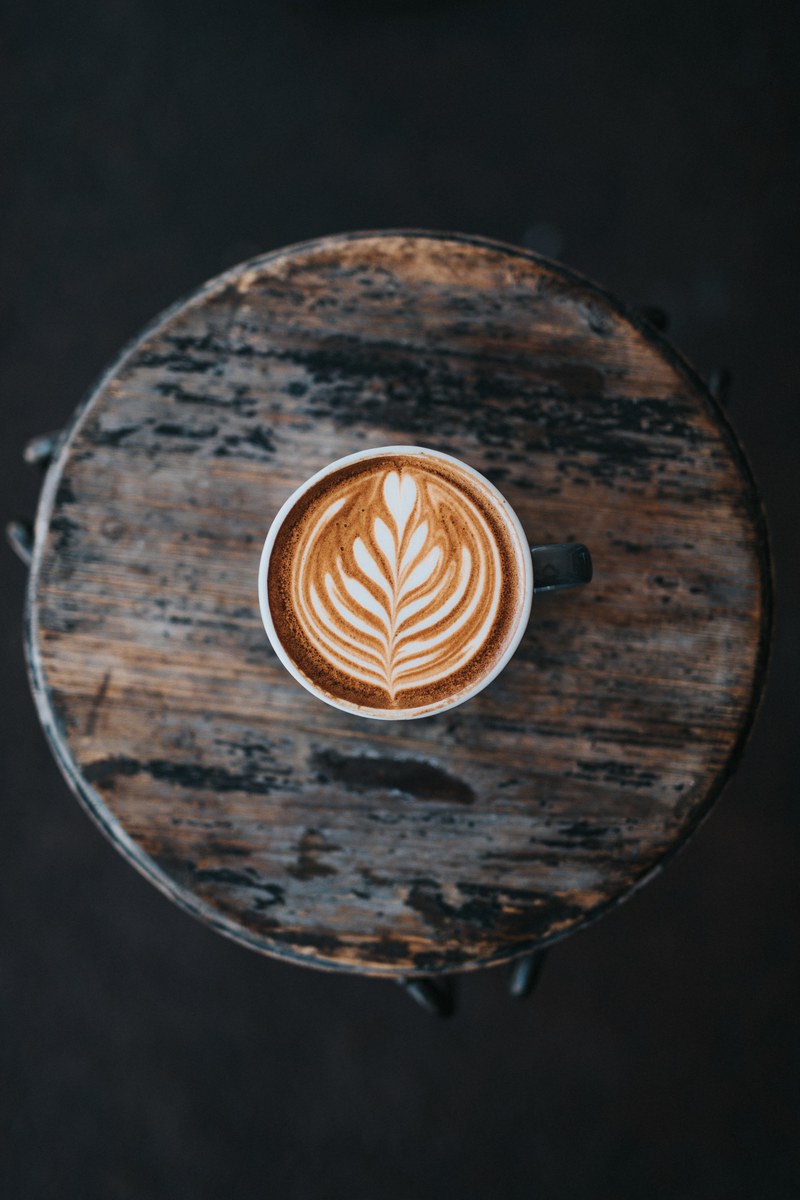 coffee latte art viewed from above in a cup on the wooden table at two guns espresso, espresso with latte art 4k