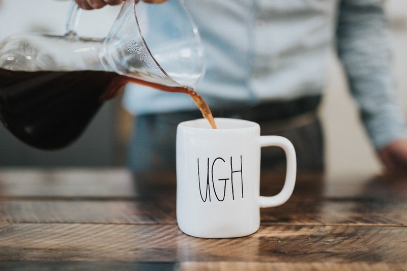 a barista pouring coffee into a mug that says ugh on it at bar nine, mondaze 4k