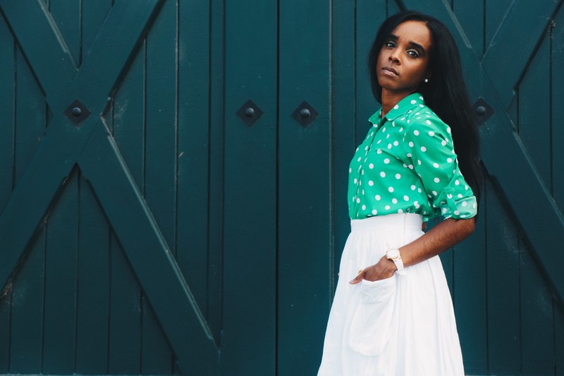 a woman with her hands in the pockets of her white skirt by blue barn doors, woman with hands in pockets 4k