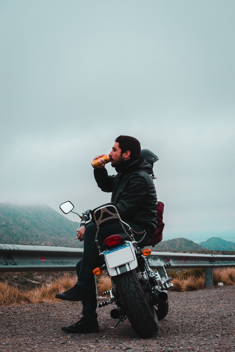 man in leather jacket drinking and sitting on motorcycle, a moment and a return 4k