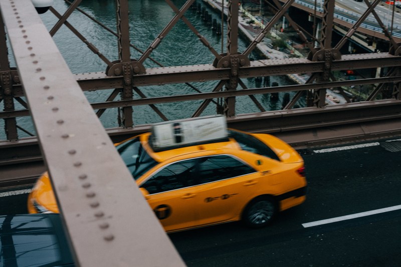 a high view of a yellow taxi cab driving on a bridge, yellow taxi cab from above 4k