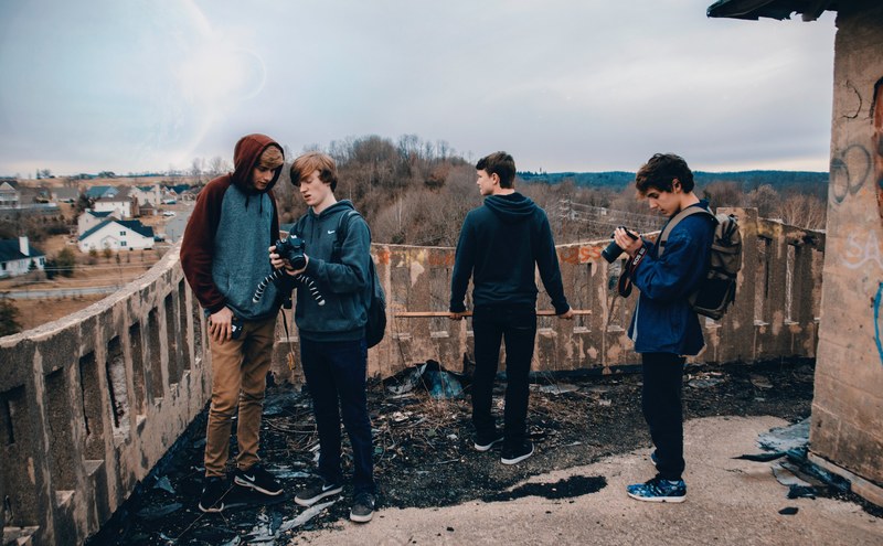 group of friends in an abandoned building admiring the scenery and checking their cameras, people on abandoned building 4k