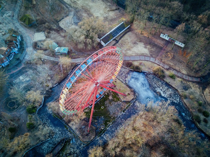 a drone shot of a red ferris wheel in a desolate area, spreepark berlin by my drone 4k