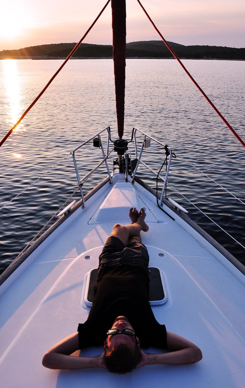 a man relaxing on his yacht on the calm water at palinski island at sunset, sailing around pakleni islands 4k