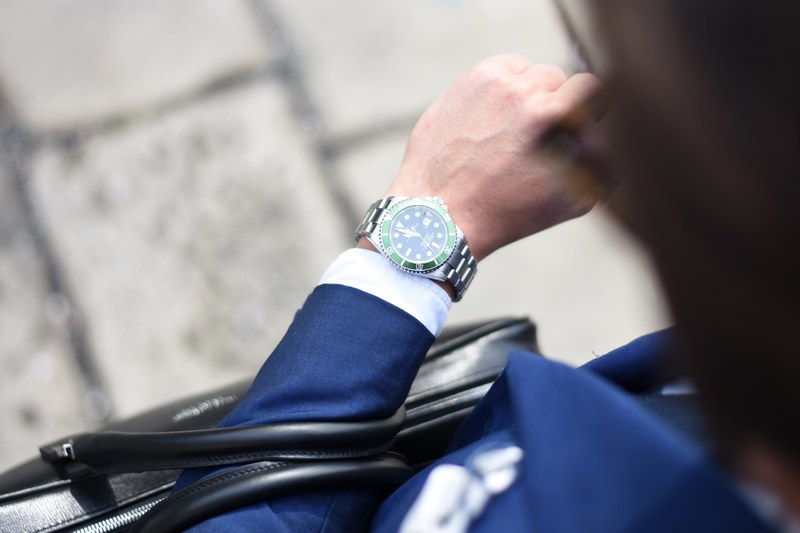 an overhead shot of a man in a navy blue suit looking at his elegant watch, businessman checking the time 4k