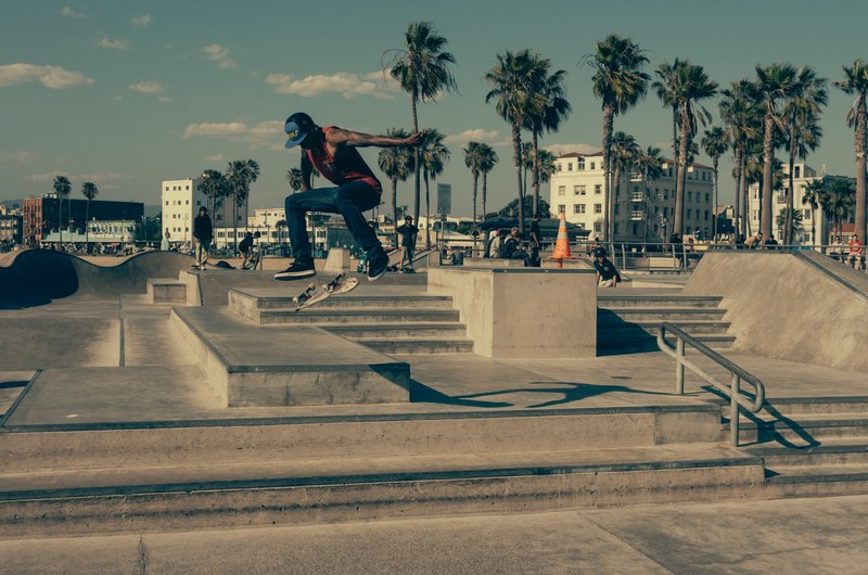 a man doing a trick on a skateboard at a skatepark by the beach, skate tricks 4k