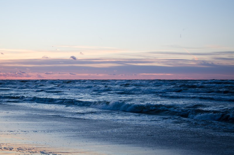 busy waves in the ocean of karwia beach with looming sunrise, ocean waves at karwia beach 4k