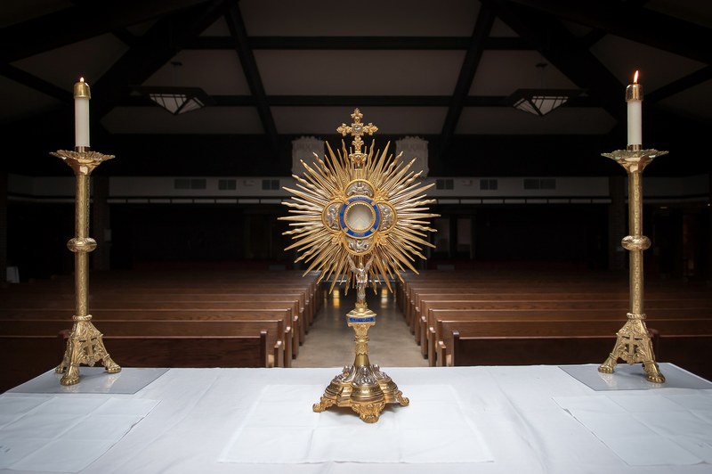 gold colored religious objects and candles on a table at the front of a church aisle, _church service objects 4k