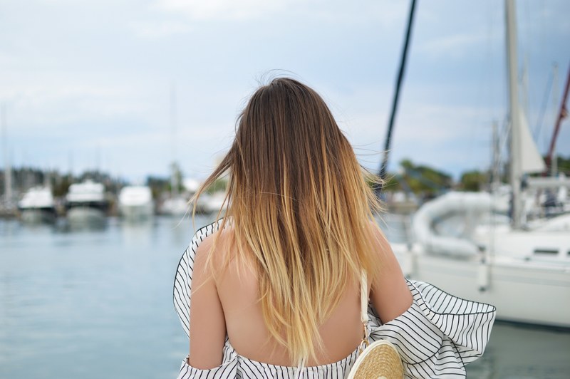 standing behind a woman in a chic striped dress near yachts, one second before the storm 4k
