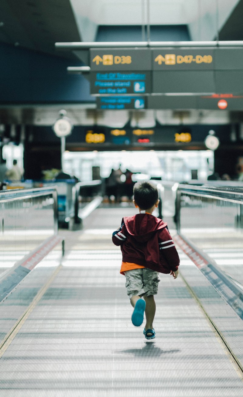 a small boy running at the airport, running late for the flight 4k