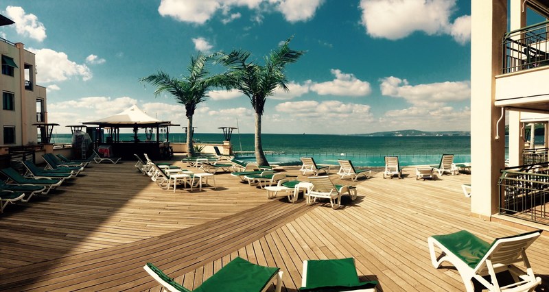 rows of empty deck chairs and palm trees on a terrace by a hotel resort, tropical hotel resort 4k