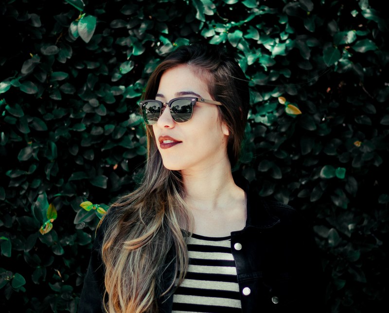 woman with sunglasses smiles and looks away, confident fall look 4k