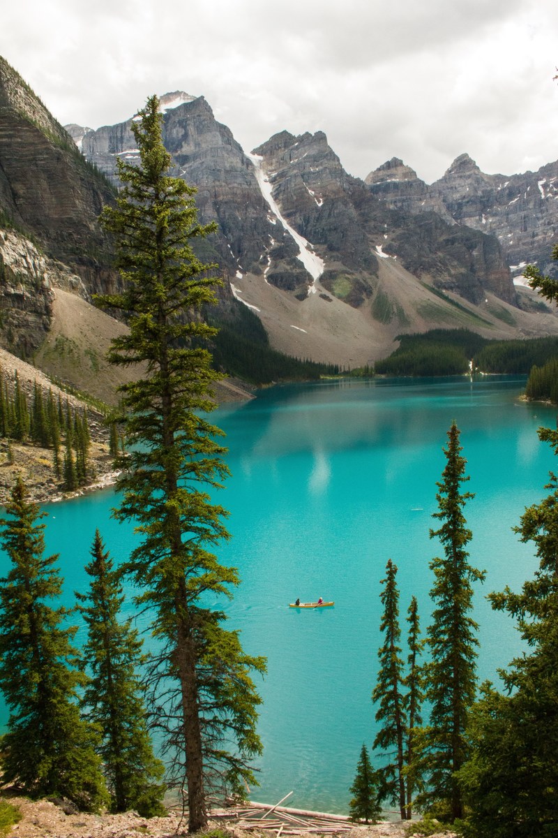 a canoe on the azure surface of a mountain lake, lady lake 4k
